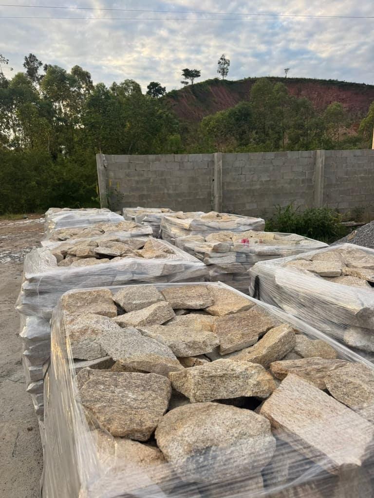 Paletes de pedra natural paletizados e embalados no pátio, prontos para embarque